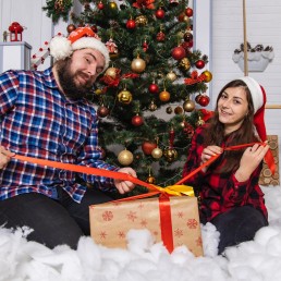 man and woman sitting on white snow