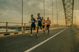 four men running on asphalt floor