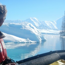 a man in a life jacket looking at a boat in the water